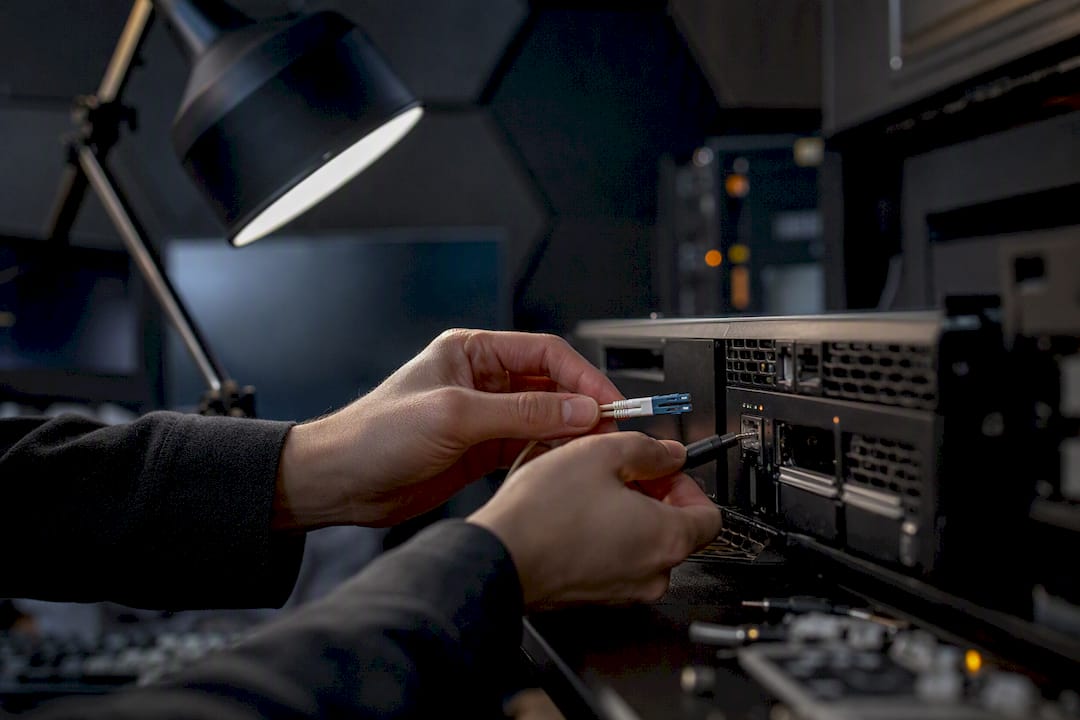 Hands plugging cable into server hardware