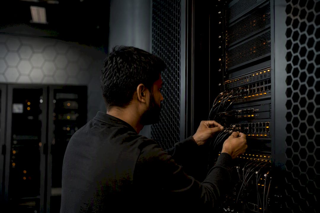 Hands connecting cables in secure server room