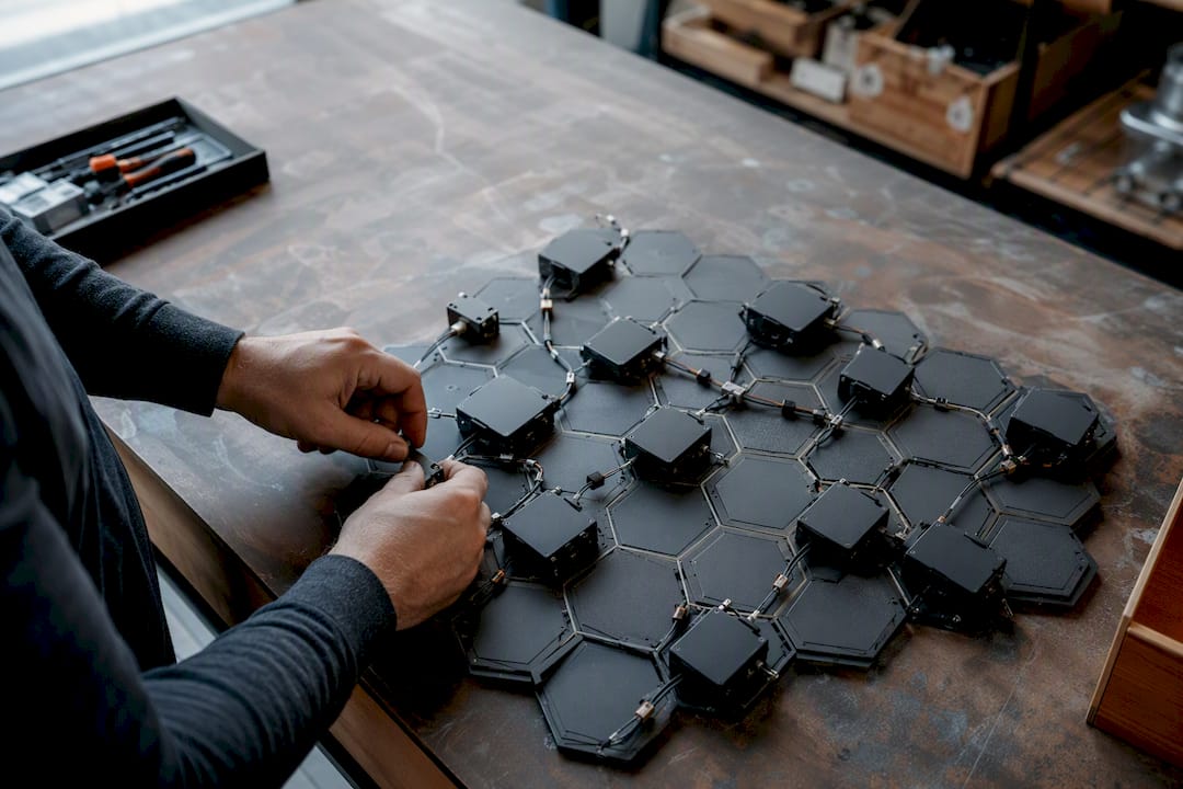 Hands configuring AI workflow modules on hex board