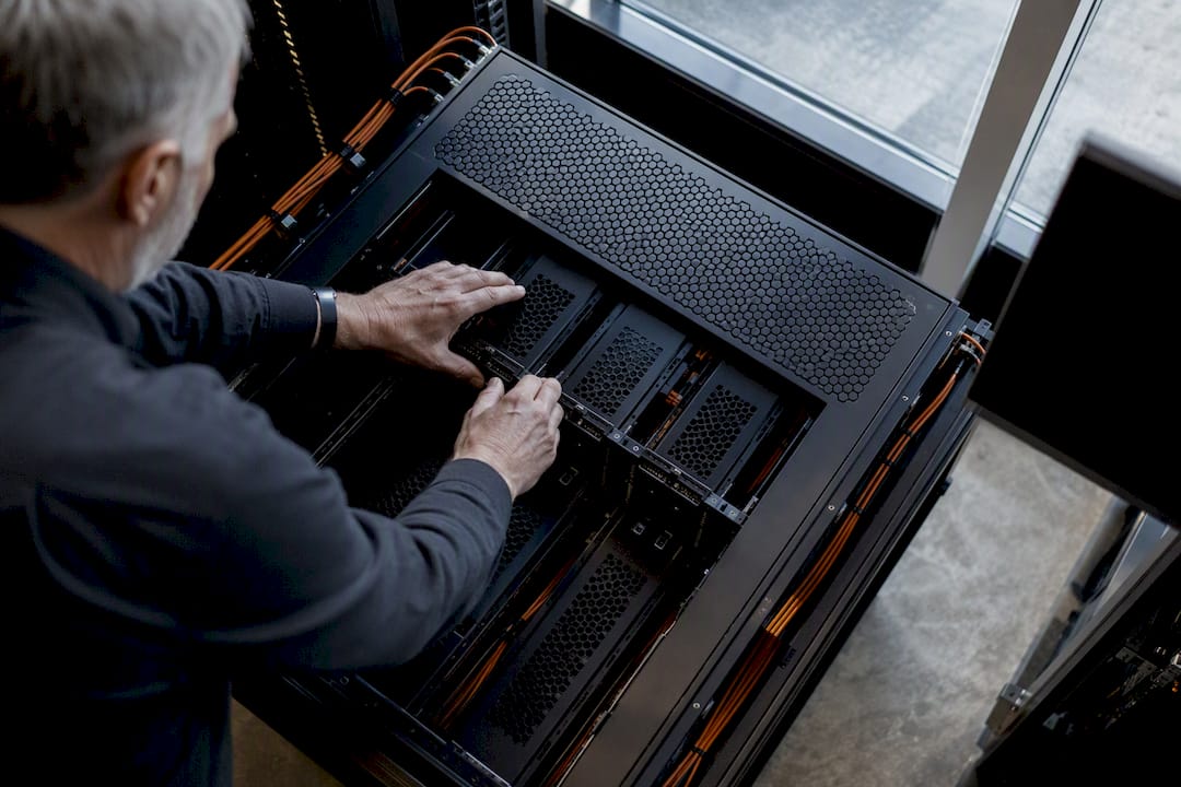 Engineer wiring AI agent modules in server rack