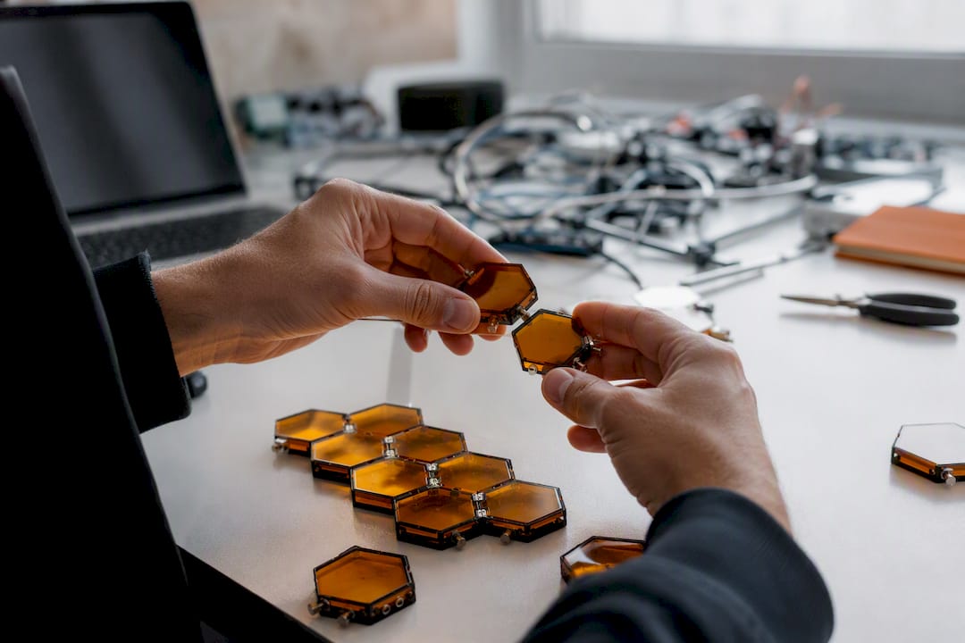 Manos montando un modelo tecnológico modular en forma de panal